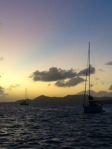 boats cruising the british virgin islands at sunset