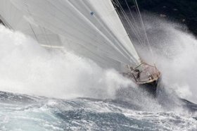 Waves clashing against a sailing boat at the Portofino Rolex Trophy.